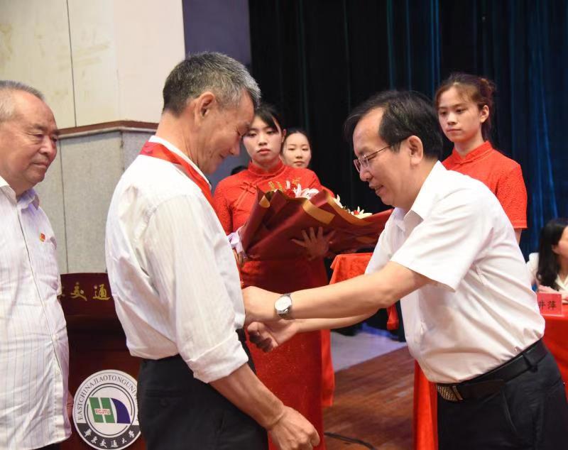 华东交通大学党委书记柳和生为老党员颁发“光荣在党50年”纪念章。
